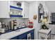 Stylish kitchen featuring white and blue cabinets, granite counters, coffee station and modern decor at 2591 Countryside Blvd # 5304, Clearwater, FL 33761