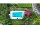 Aerial view of a large community pool surrounded by lush greenery and lounge chairs at 2591 Countryside Blvd # 5304, Clearwater, FL 33761