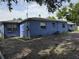 Rear exterior of the home with brick paved driveway and blue painted concrete facade at 2612 E 17Th Ave, Tampa, FL 33605