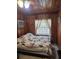 Quaint bedroom featuring wood paneled walls, decorative window bars and a neutral color quilt at 2612 E 17Th Ave, Tampa, FL 33605