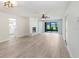 Open-concept living room with modern flooring, fireplace, and access to screened patio at 3568 Wilkinson Woods Dr # 23, Sarasota, FL 34231