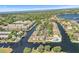 An aerial view shows a neighborhood surrounded by canals, boats, pools and lush greenery at 358 Moorings Cove Dr # 4B, Tarpon Springs, FL 34689