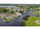 Aerial view of waterfront community featuring condos, canals, private docks, lush greenery, and a sparkling pool at 358 Moorings Cove Dr # 4B, Tarpon Springs, FL 34689