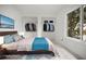 This staged bedroom features built-in closets, minimalist decor, and a bright window at 358 Moorings Cove Dr # 4B, Tarpon Springs, FL 34689