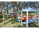 Community kayak storage with colorful kayaks in the rack, nestled amongst shady trees and lush greenery at 358 Moorings Cove Dr # 4B, Tarpon Springs, FL 34689