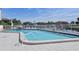 Community pool features a pristine pool with clear blue water, surrounded by ample lounge chairs and a tranquil waterfront view at 358 Moorings Cove Dr # 4B, Tarpon Springs, FL 34689
