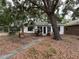 A single-story home with a white exterior and large tree in the front yard at 4050 Iris N St, St Petersburg, FL 33703