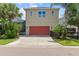 Rear exterior of a two-story home featuring a vibrant red garage door and a screened-in pool, with lush landscaping at 5955 Caldera Ridge Dr, Lithia, FL 33547