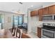 Open-concept design with living room and kitchen featuring modern appliances and wooden cabinets at 5955 Caldera Ridge Dr, Lithia, FL 33547