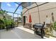 Cozy screened lanai with outdoor grill and sitting area provides a relaxing space for outdoor dining and backyard entertaining at 5955 Caldera Ridge Dr, Lithia, FL 33547