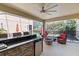 Outdoor living and dining area on a screened lanai features an outdoor kitchen with grill and a cozy seating area with a fire pit at 5955 Caldera Ridge Dr, Lithia, FL 33547