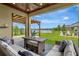 View of the covered lanai featuring comfortable seating and views of the backyard and pond at 6555 Kenava Loop, Palmetto, FL 34221