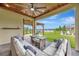 View of the covered lanai featuring comfortable seating and views of the backyard and pond at 6555 Kenava Loop, Palmetto, FL 34221