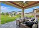 View of the covered lanai featuring comfortable seating and a backyard with a fire pit at 6555 Kenava Loop, Palmetto, FL 34221