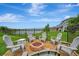 Backyard features a fire pit with chairs, perfect for outdoor entertaining with a picturesque lake view at 6555 Kenava Loop, Palmetto, FL 34221