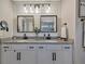 Bright bathroom featuring a double vanity with granite countertops, modern lighting, and fixtures at 6555 Kenava Loop, Palmetto, FL 34221