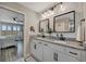 Bright bathroom features double sinks, granite counters, a shiplap wall, and access to the main bedroom at 6555 Kenava Loop, Palmetto, FL 34221