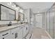 Bright bathroom with double vanity, modern fixtures, and glass-enclosed shower at 6555 Kenava Loop, Palmetto, FL 34221