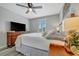 Bedroom with wood-look floors, ceiling fan, and a window with wood shutters for natural light at 6555 Kenava Loop, Palmetto, FL 34221
