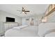 Bright primary bedroom with wood floors, ceiling fan, and neutral decor at 6555 Kenava Loop, Palmetto, FL 34221