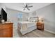 Bedroom with wood-look floors, ceiling fan, and a window with wood shutters for natural light at 6555 Kenava Loop, Palmetto, FL 34221
