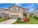 Charming two-story home showcasing a well-manicured lawn and inviting front garden at 6555 Kenava Loop, Palmetto, FL 34221