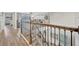 Upstairs hallway with wood floors and decorative iron railing overlooking the living room at 6555 Kenava Loop, Palmetto, FL 34221