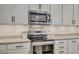 Close up of kitchen features, including stainless steel microwave and oven with stylish backsplash at 6555 Kenava Loop, Palmetto, FL 34221