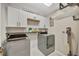 Convenient laundry room features modern appliances, white cabinets, and wood shelving at 6555 Kenava Loop, Palmetto, FL 34221