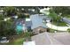 Aerial view of a beautiful home featuring a screened-in pool, spacious yard, and well-maintained landscaping at 713 Rustic Oaks Dr, Palm Harbor, FL 34684