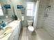 The bathroom features tile floors, a white vanity and toilet, and a tiled shower/tub combo at 713 Rustic Oaks Dr, Palm Harbor, FL 34684