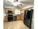 Updated kitchen with stainless steel appliances, granite countertops, and natural wood cabinets at 713 Rustic Oaks Dr, Palm Harbor, FL 34684
