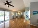Open-concept living area with hardwood floors and a seamless connection to the outdoor screened-in pool at 713 Rustic Oaks Dr, Palm Harbor, FL 34684