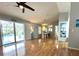 Bright living room with wood floors, ceiling fan, sliding glass doors to pool area, and neutral paint at 713 Rustic Oaks Dr, Palm Harbor, FL 34684