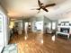 Open-concept living room with fireplace, wood floors, and access to the kitchen and outdoor living spaces at 713 Rustic Oaks Dr, Palm Harbor, FL 34684