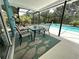 Cozy outdoor patio dining area overlooking a screened pool and lush landscape at 713 Rustic Oaks Dr, Palm Harbor, FL 34684