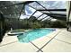 Inviting screened-in pool with a jacuzzi and lush landscaping at 713 Rustic Oaks Dr, Palm Harbor, FL 34684