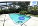 Beautiful screened-in pool with tropical plants and lush landscape at 713 Rustic Oaks Dr, Palm Harbor, FL 34684