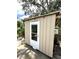 Exterior view of a small shed with white door and window at 713 Rustic Oaks Dr, Palm Harbor, FL 34684