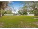 Spacious backyard showcasing a screened-in pool, mature trees, and a shed at 7607 New York Ave, Hudson, FL 34667