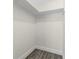 Walk-in closet with built-in shelving and wood-look flooring at 7607 New York Ave, Hudson, FL 34667