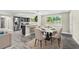 Open-concept dining area adjacent to kitchen, featuring stylish table set for six with view of backyard at 7607 New York Ave, Hudson, FL 34667