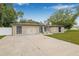 Exterior showcasing stone accents, a driveway, and well-manicured lawn at 7607 New York Ave, Hudson, FL 34667