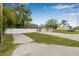 Well-maintained exterior with a long driveway and lush landscaping at 7607 New York Ave, Hudson, FL 34667