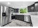 Well-lit kitchen with stainless steel appliances, dark cabinets, and white countertops, window view at 7607 New York Ave, Hudson, FL 34667