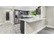 Modern kitchen featuring stainless steel appliances, dark cabinetry, and a bright white countertop island at 7607 New York Ave, Hudson, FL 34667