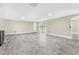 Bright living room with wood-look flooring, light-colored walls, and sliding glass doors to a screened-in pool area at 7607 New York Ave, Hudson, FL 34667
