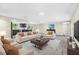 Spacious living room with view into kitchen, features modern furnishings and neutral color palette at 7607 New York Ave, Hudson, FL 34667