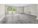 Open living room with wood-look flooring, bright window, and ample natural light at 7607 New York Ave, Hudson, FL 34667