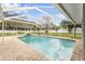 Relaxing screened-in pool area with a waterfall feature, surrounded by a well-maintained backyard at 7607 New York Ave, Hudson, FL 34667